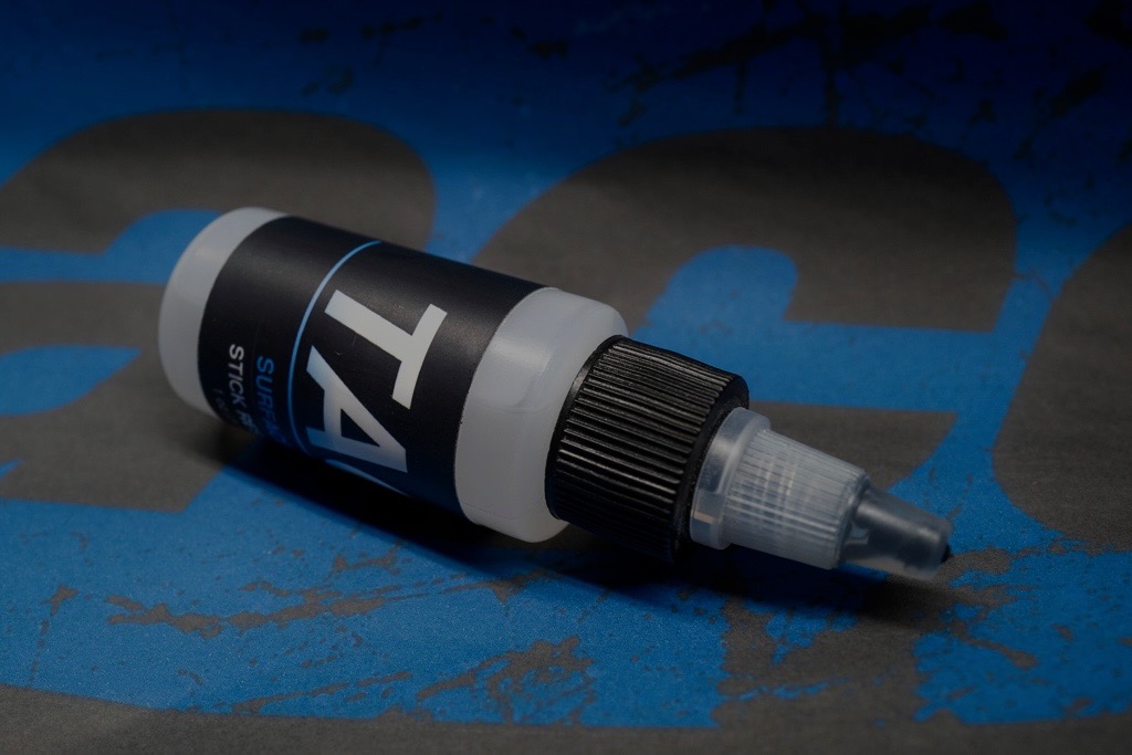 TACC Surface Lock dropper bottle on a blue and black climbing-inspired surface